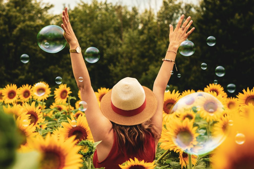 women surrounded by sunflowers